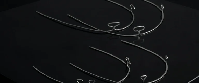 Orthodontic NiTi arches on a dark background, illustration of the arch systems in Munich-Schwabing