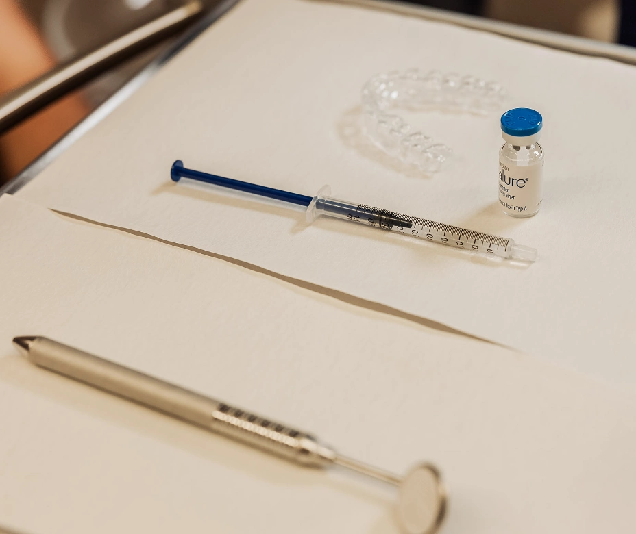 Ablage mit Schiene, Feindosierspritze und Wirkstofffläschchen für die gestufte CMD-Behandlung aus der kieferorthopädischen Praxis in München