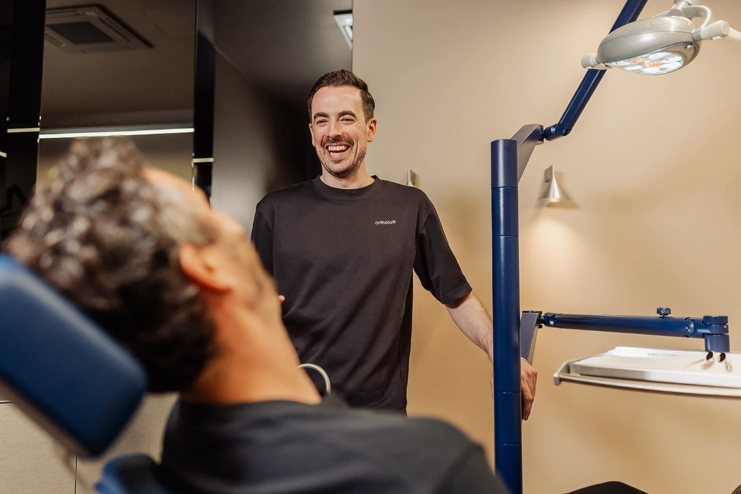 Dr. Dominik Pfeil im Gespräch mit einem Patienten im Behandlungszimmer in München-Schwabing