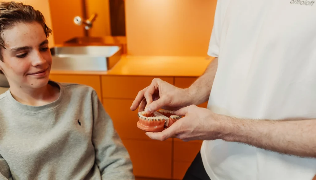 Explanation of fixed braces using a demonstration model with brackets in the treatment room