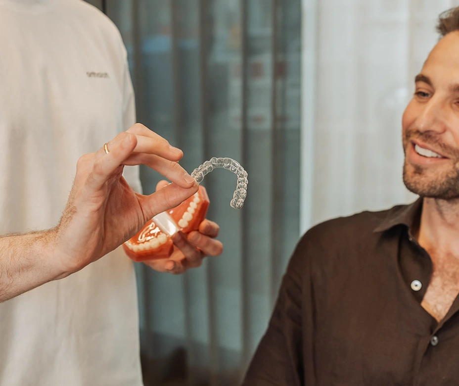 Gerade Zähne mit Aligner: transparente Schiene am Kiefermodell bei ortholoft, Kieferorthopäde München