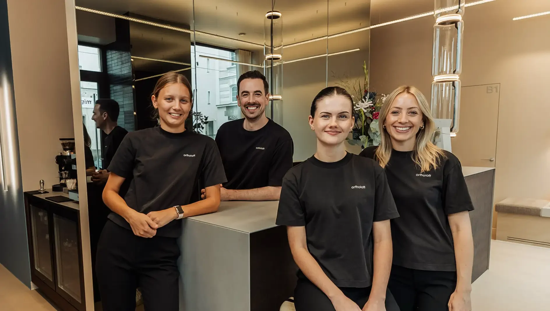 Das Praxisteam von ortholoft am Empfang der kieferorthopädischen Praxis in der Nordendstraße in München