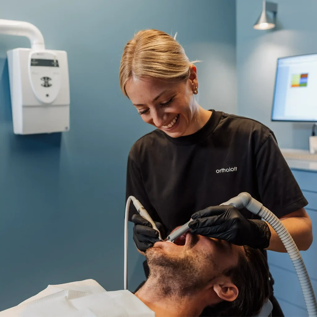 Mitarbeiterin von ortholoft bei der professionellen Zahnreinigung im Behandlungszimmer in der Nordendstraße in München